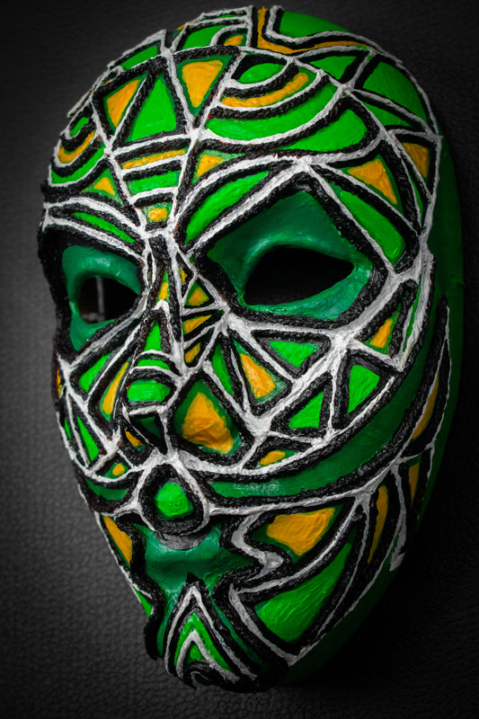 Masque artisanal vert avec motifs peints à la main.