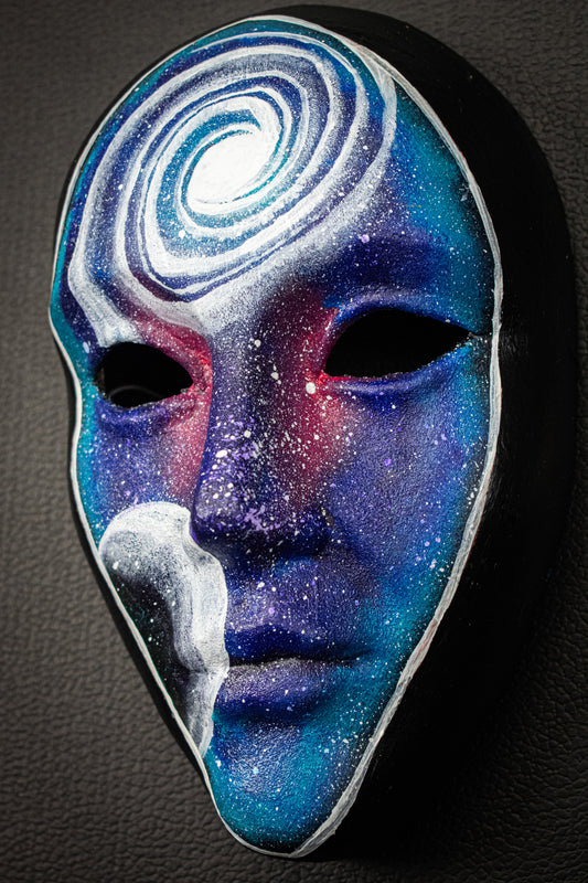 Masque artisanal noir avec motifs peints à la main.