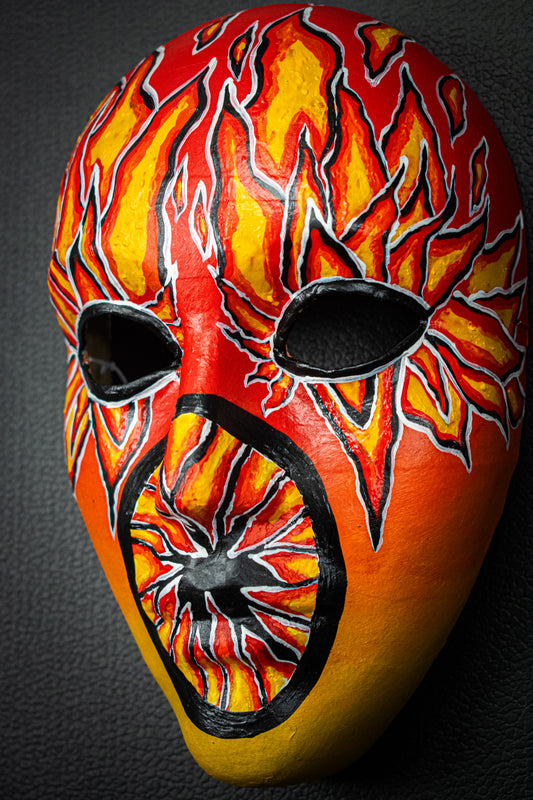 Masque artisanal orange avec motifs noir peints à la main.