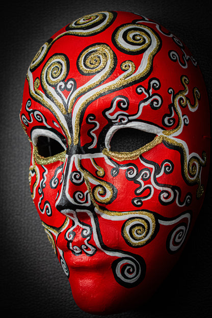 Masque artisanal rouge avec motifs peints à la main. 