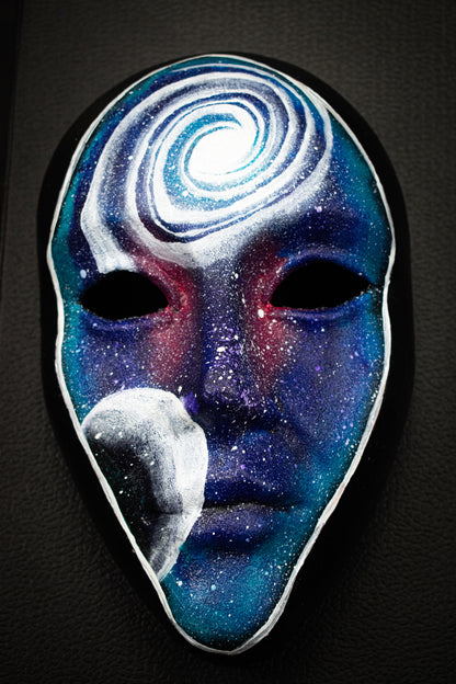 Masque artisanal noir avec motifs peints à la main.