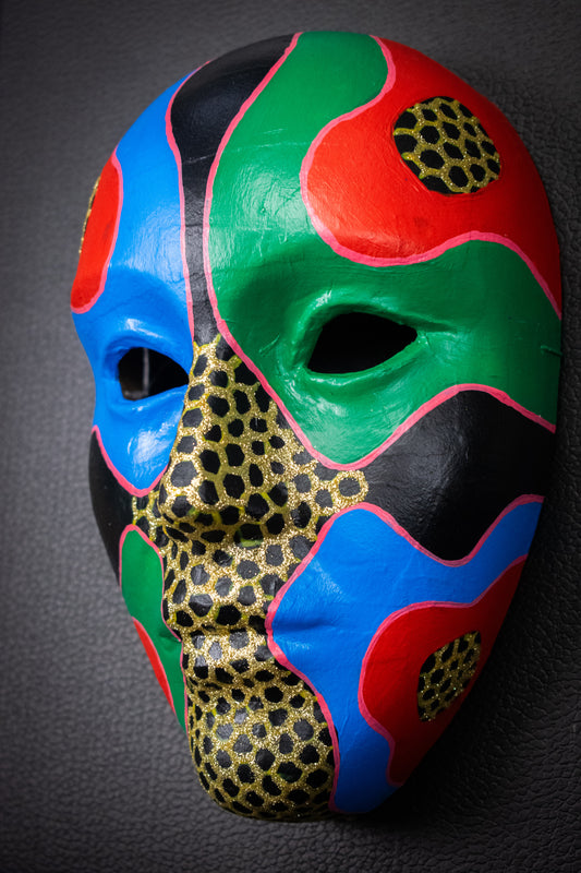 Masque artisanal rouge, bleu, vert avec motifs peints à la main.